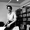 Joel Shprentz sits atop the Skee-Ball machine to reach some pinball parts.