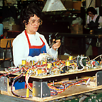 A technician solders parts on a Williams Taxi playfield.
