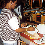 Applying Taxi labels to game toppers at the Williams pinball factory