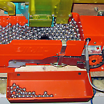 Ball lifter unit collects balls and pushes them up the metal channel.