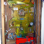 Back of pachinko game reveals ball lifter unit and window-like framing.